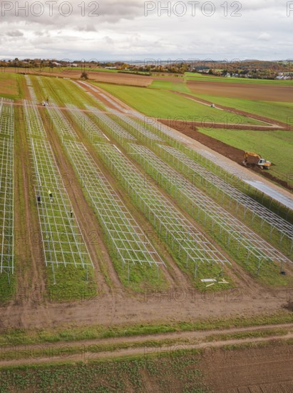 Start of a solar plant in fields with technical structures and a green environment, energy revolution, construction of PV open space, Baden-Württemberg, Germany