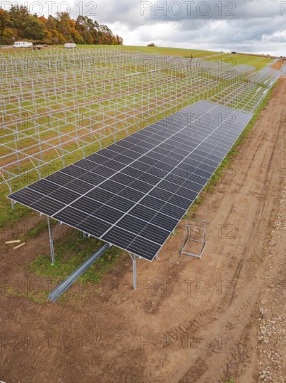 Solar system construction on a wide, cloudy field landscape, energy revolution, construction of PV open space, Baden-Württemberg, Germany