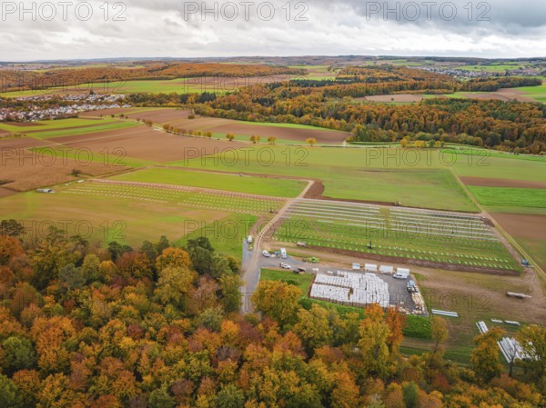 Autumn panorama with colorful foliage, fields and a small village in the distance, Energiewende, construction of PV open space, Baden-Württemberg, Germany