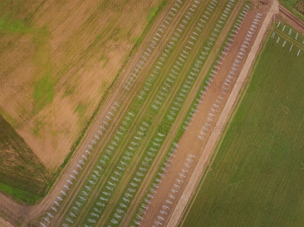 Aerial view of fields with staggered solar frame placement, surrounded by brown and green areas, energy transition, construction of PV open space, Baden-Württemberg, Germany