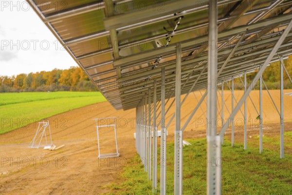 Metal structure for solar panels in a field next to an autumn forest, energy revolution, construction of PV open space, Baden-Württemberg, Germany