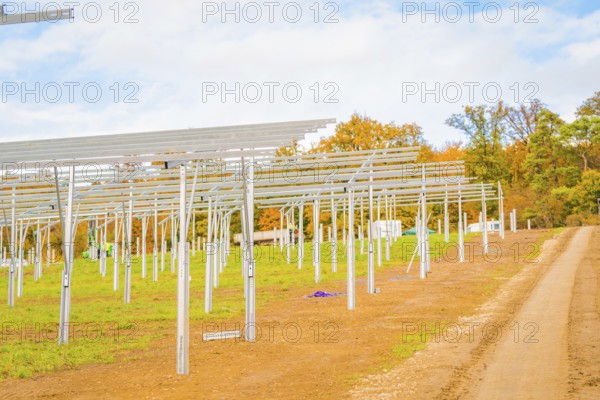 Extensive site with metal structures for solar panels and autumn sky, energy revolution, construction of PV open space, Baden-Württemberg, Germany