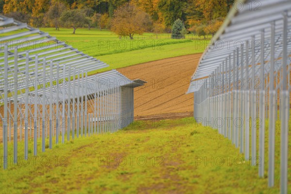 Metal frame for solar panels in autumn landscape with green meadows, energy revolution, construction of PV open space, Baden-Württemberg, Germany