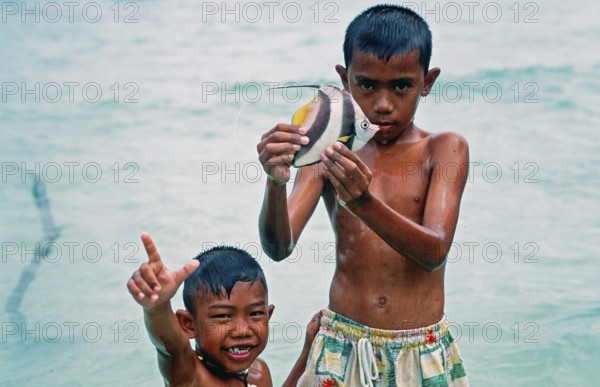 Two boys with a tropical fish on Ko Phi Phi Don, two years in front of the tsunami, Thailand, December 2002, vintage, retro, old, historic