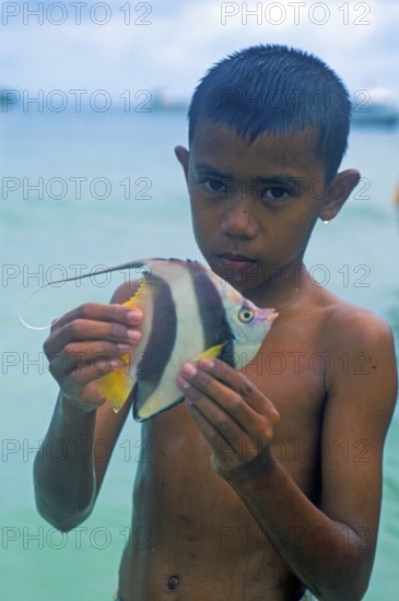 Boy with a tropical fish on Ko Phi Phi Don, two years in front of the tsunami, Thailand, December 2002, vintage, retro, old, historic