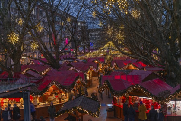 Christmas market on Holstenplatz in Kiel, city center, trees, shops, pedestrian zone, early evening, stalls, visitors, glowing stars, lights, Christmas decorations, fun, festive atmosphere, Christian festival, view from above, Schleswig-Holstein, Germany