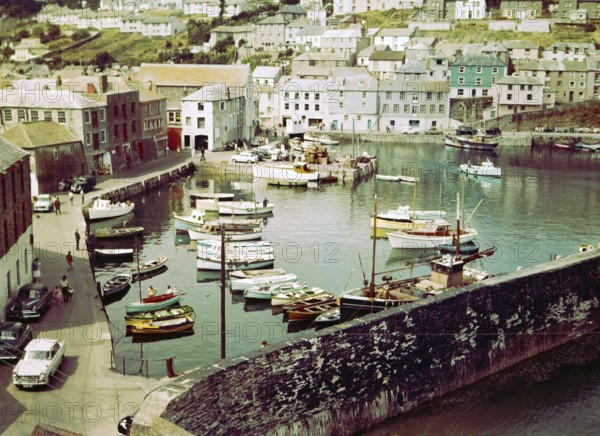 Boats at moorings in the harbour at seaside fishing village of Mevagissey, Cornwall, England, UK c 1960