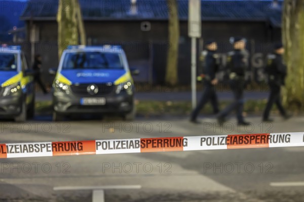 Flutter tape with the inscription police barrier. Behind them, police vehicles. Stuttgart, Baden-Württemberg, Germany