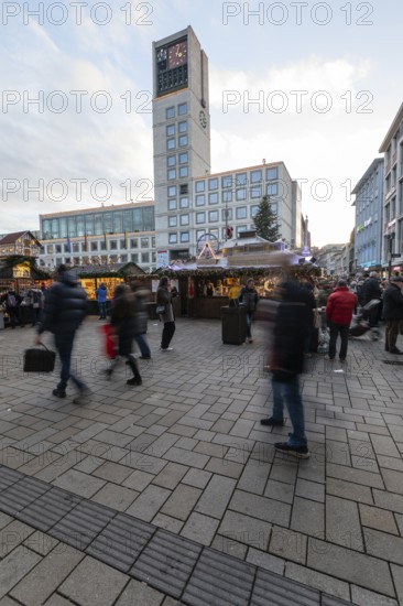 The Christmas market on the market square, in front of Stuttgart City Hall 2025, shines in festive lights in the evening. Many people visit the stands and enjoy the Christmas atmosphere