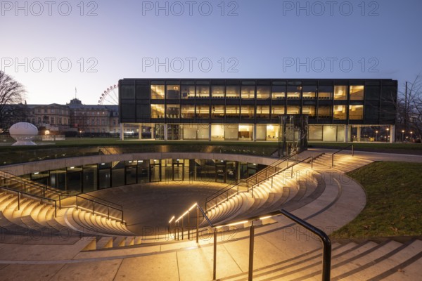 The state parliament of Stuttgart glows impressively in the evening. The architecture is accentuated by the night light and creates a clear, atmospheric atmosphere