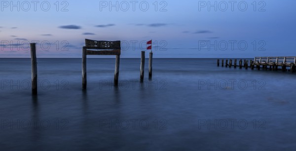 Wooden sign in the sea with inscription Zingst and wooden walkway, long exposure, evening light, Zingst, Fischland-Darß-Zingst, Western Pomerania National Park, Mecklenburg-Western Pomerania, Germany