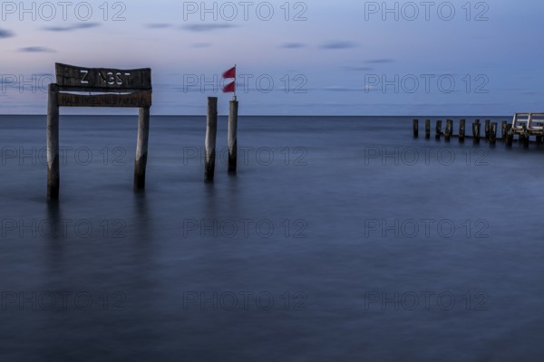 Wooden sign in the sea with inscription Zingst and Buhnen, long exposure, evening light, Zingst, Fischland-Darß-Zingst, Western Pomerania National Park, Mecklenburg-Western Pomerania, Germany