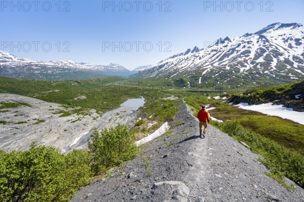 Hikers on glacial moraine, view of the vast Tsina River valley with mountains, Worthington Glacier Lagoon, Worthington Glacier State Recreational Site, Chugach Mountains, Alaska, USA