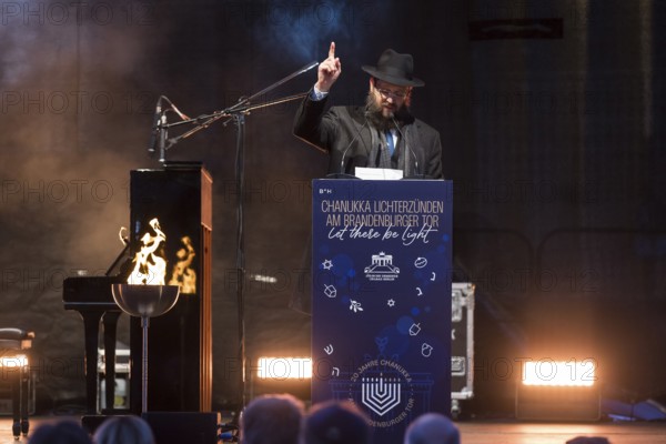 Yehuda Teichtal (Rabbi of the Chabad-Lubavitch movement) speaks at the lighting of lights to mark 20 years of Hanukkah in front of the Brandenburg Tor tor, Berlin, 17 December 2025