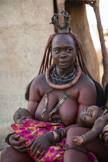 Himba woman with baby, traditional Himba village, Kaokoveld, Kunene, Namibia