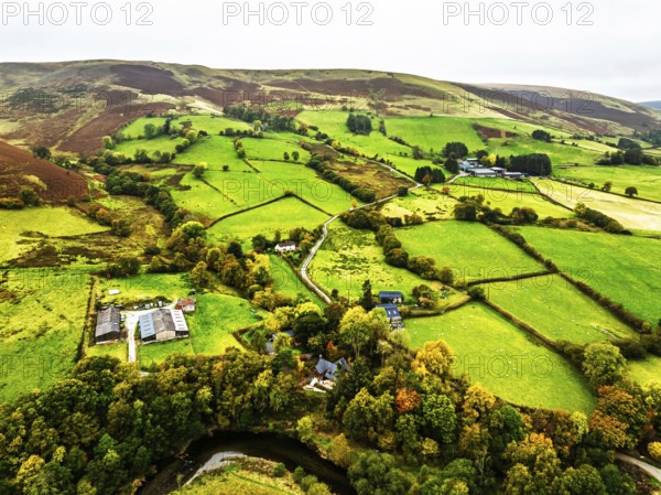 Autumn colours of Farms over River Wye and Road A470 from a drone, Llanidloes, Powys, Montgomeryshire, Wales, UK