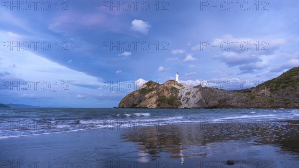 Castlepoint Beach, ocean and lighthouse on a rock, in the evening, after sunset. Castlepoint, Wairarapa Coast, Wellington Region, North Island, New Zealand