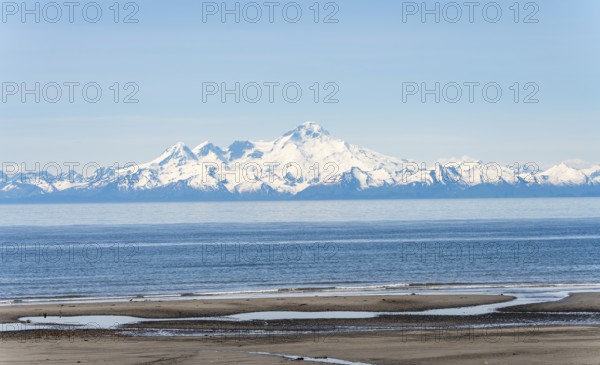 Beach at Anchor Point, Cook Inlet, glaciated mountain peaks of the Aleutian Range with Mount Iliamna summit, Anchor River State Recreation Area, Alaska, USA