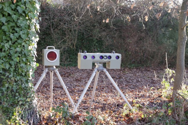 Radar meter, lightning system, traffic monitoring, speed control, speed shifter, A mobile radar system with photo camera is hidden between trees on the side of the road