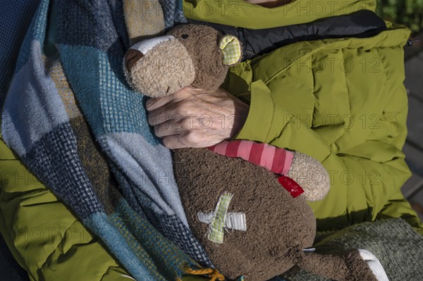 Hand of an old woman holding her stuffed bear from her childhood, Bavaria, Germany