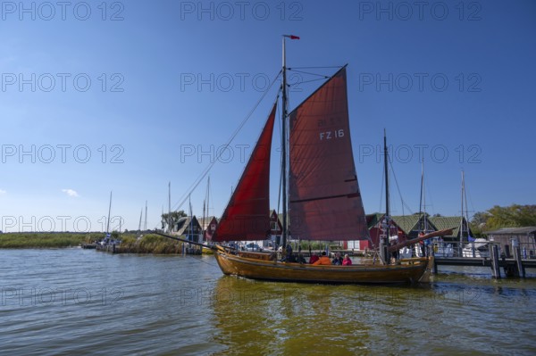 Zeesboot, former historic fishing boat, leaves the port of Ahrenshoop, blue sky, Darß, Mecklenburg-Western Pomerania, Germany