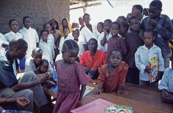 In a World Vision project, friends and neighbors have gathered on the occasion of a godfather's visit, Nyabubinza, Tanzania, Africa, June 2000, vintage, retro, old, historic