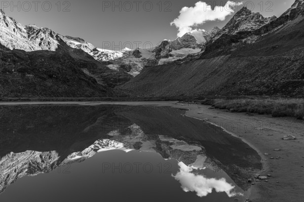 The Moiry glacier and mountain peaks are reflected in Lac de Chateaupre, black and white photo, Val d'Anniviers, Valais Alps, Canton of Valais, Switzerland