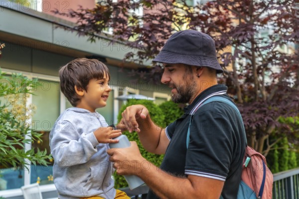 Father and son sharing a joyful bonding moment in vancouver, as dad opens a water bottle for his delighted child, emphasizing the importance of family time and healthy hydration