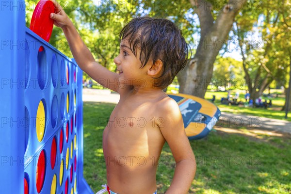 Happy child playing connect four in a vibrant park in kamloops, british columbia, soaking up the sun on a delightful summer day filled with outdoor fun and laughter