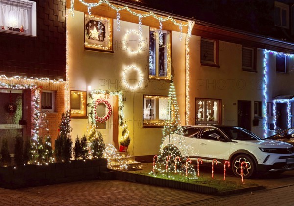 Christmassy kitschy illuminated façade of a row house in Gelsenkirchen-Ückendorf in the evening, Ruhr area, North Rhine-Westphalia, Germany