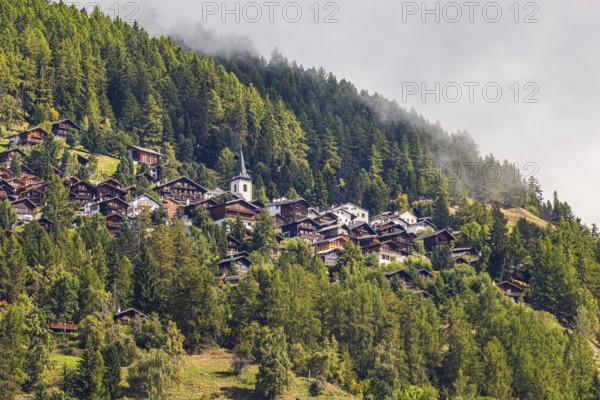 Rising fog over the mountain village of Saint-Luc, Val d'Anniviers, Valais Alps, Canton of Valais, Switzerland