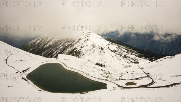 Another onset of winter in May, Riezler Alpsee, an artificially created lake, snow pond, feeds the snow cannons that completely snow the slopes of the Fellhorn and Kanzelwand cable cars, Allgäu Alps, Vorarlberg, Austria
