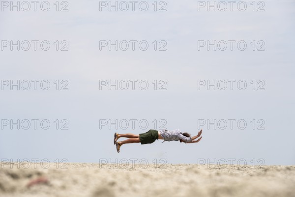 Abstract, man jumping horizontally at the Etosha pan, salt pan, Etosha National Park, Namibia