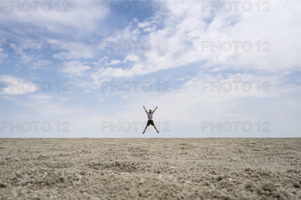 Symbolic picture, abstract, man jumping on the Etosha pan, salt pan, Etosha National Park, Namibia