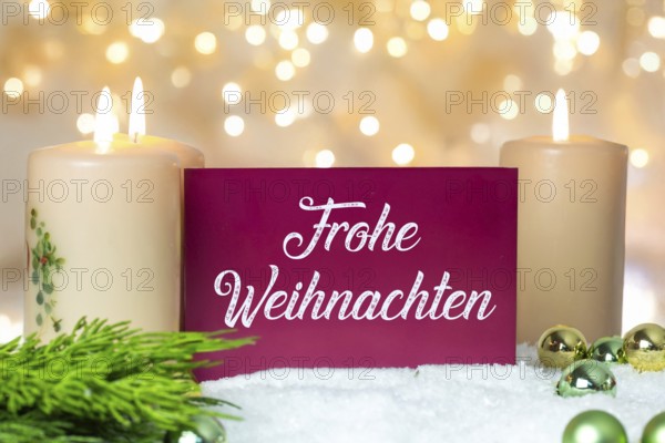 Greeting card with the inscription FROHE WEIHNAHCHTEN between Christmas accessories with bokeh in the background (digitally reworked)