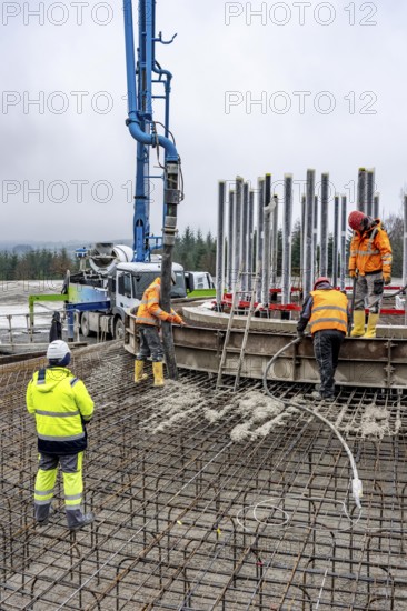 Concreting, concreting the foundation of a wind turbine, more than 600 cubic meters of concrete will be pumped into the foundation for over 7 hours, over 100 tons of reinforcing steel have been used, the wind turbine will have a hub height of 160 meters, part of a new wind farm in Sauerland, near Balve, North Rhine-Westphalia, Germany