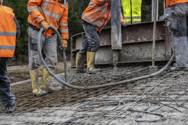 Concreting, concreting the foundation of a wind turbine, concrete pump hose, compressor, more than 600 cubic meters of concrete will be pumped into the foundation for over 7 hours, over 100 tons of reinforcing steel have been used, the wind turbine will have a hub height of 160 meters, part of a new wind farm in Sauerland, near Balve, North Rhine-Westphalia, Germany