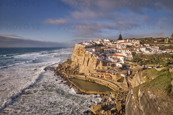 Scenic view of the seaside Azenhas do Mar fishing village on cliff on Atlantic ocean coast, Portugal on sunset