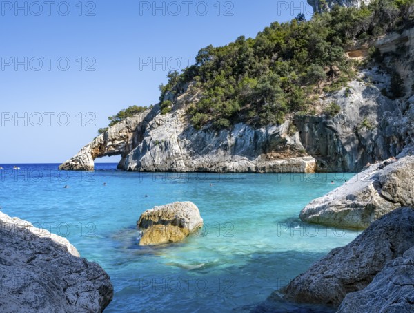 Light blue clear sea on a dream beach on Cala Goloritzé, picturesque rocky coast, cliffs with rock arch, Golfo di Orosei, Baunei, Sardinia, Italy