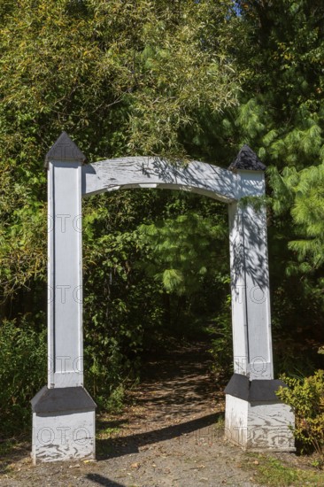 White painted wooden portal gate at start of hiking trail in public nature park in late summer, Parc du Grand-Coteau, Mascouche, Quebec, Canada