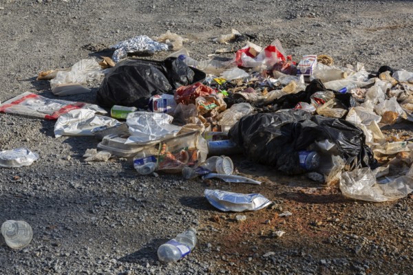 Recyclable plastic, paper and cardboard items discarded on the ground in public park, Quebec, Canada