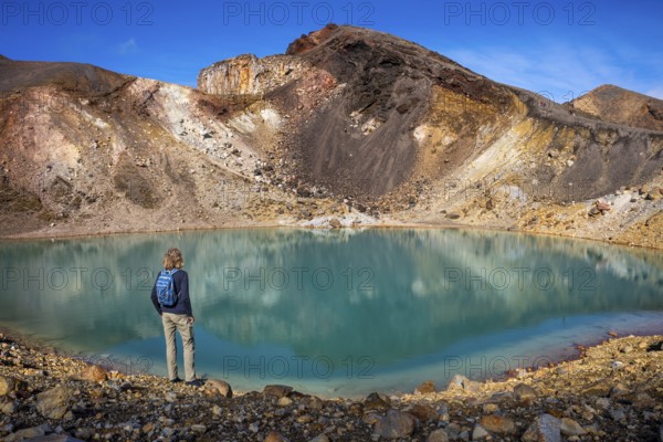 A hiker at one of the Emerald Lakes and Red Crater, Panorama, Tongariro alpine crossing, Tongariro National Park, North Island, New Zealand