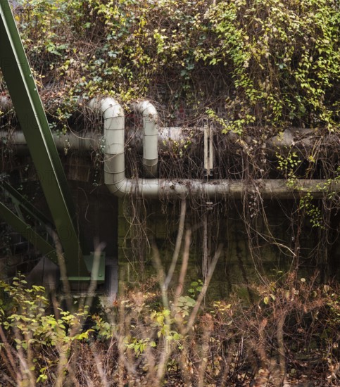 District heating pipeline in front of old industrial buildings on the banks of the Wupper, Wuppertal, Germany