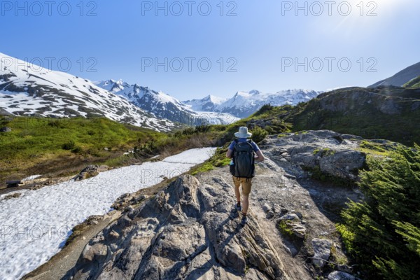 Hikers on the Portage Pass Trail, snow-covered mountains and Portage Glacier glaciers, near Whittier, Alaska, USA