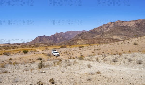 Toyota Hilux off-road vehicle on a sandy track, desert landscape with Brandberg, Erongo, Damaraland, Namibia