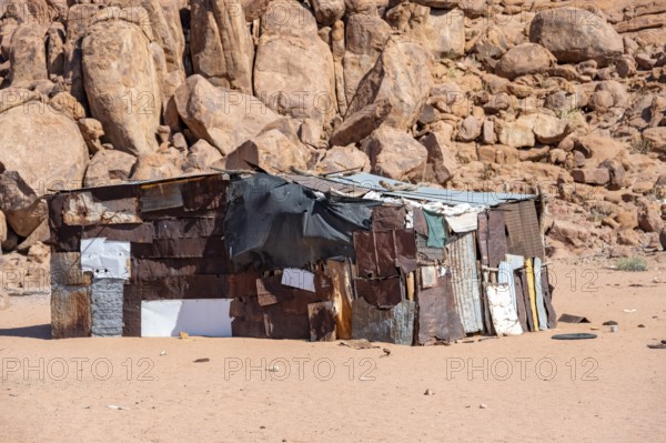 Simple poor huts made of corrugated iron and wood, desert landscape, barren landscape with hills of stacked rocks, Brandberg, Erongo, Damaraland, Namibia