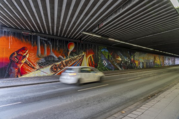 Huge street art pictures in a road tunnel in Gelsenkirchen, the approximately 120 meter long railway underpass of Wickingstraße was extensively painted and sprayed on both sides by 11 Gelsenkirchen graffiti artists and collectives, over a total length of 174 meters, the wall paintings showed motifs from Gelsenkirchen history, from economy, coal, steel, soccer, culture, life, on the 150th anniversary of the city on 29.11.11.25, North Rhine-Westphalia, Germany