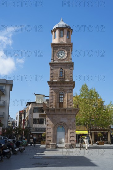 A tall clock tower in an urban square with trees and shops, Çanakkale Clock Tower, Canakkale, Marmara Region, Turkey