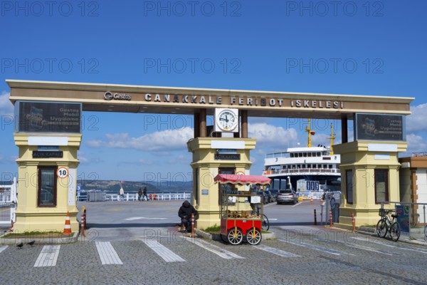 The entrance to the ferry terminal with clock and a kiosk in sunny weather, Çanakkale, Canakkale, Marmara region, Turkey