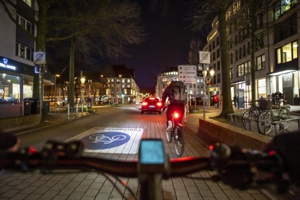 Cycling in the city, in the dark, in the evening, inner-city road, bicycle road, two-wheeler traffic has priority, 30 km/h zone, cyclist perspective, Essen, North Rhine-Westphalia, Germany